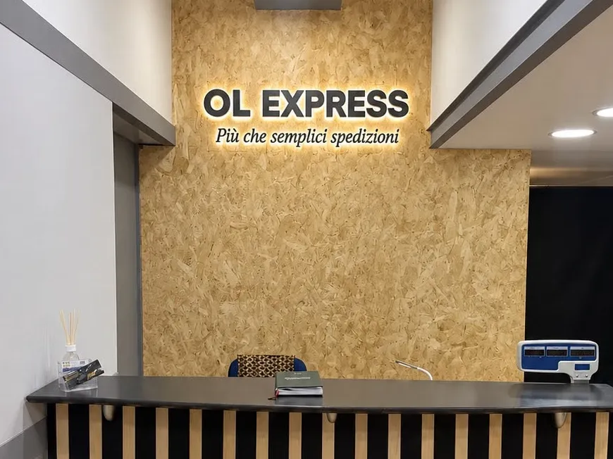 Il bancone di OL EXPRESS con l’insegna luminosa «Più che semplici spedizioni»
